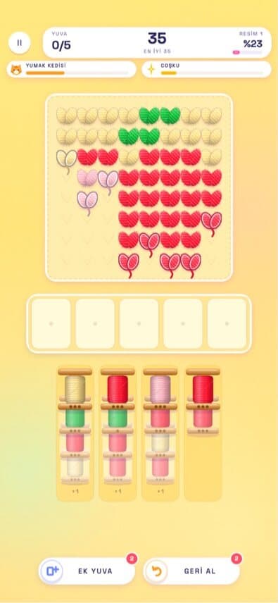 ILMEK gameplay: a yarn-sorting puzzle with a heart pattern above spools of coloured thread